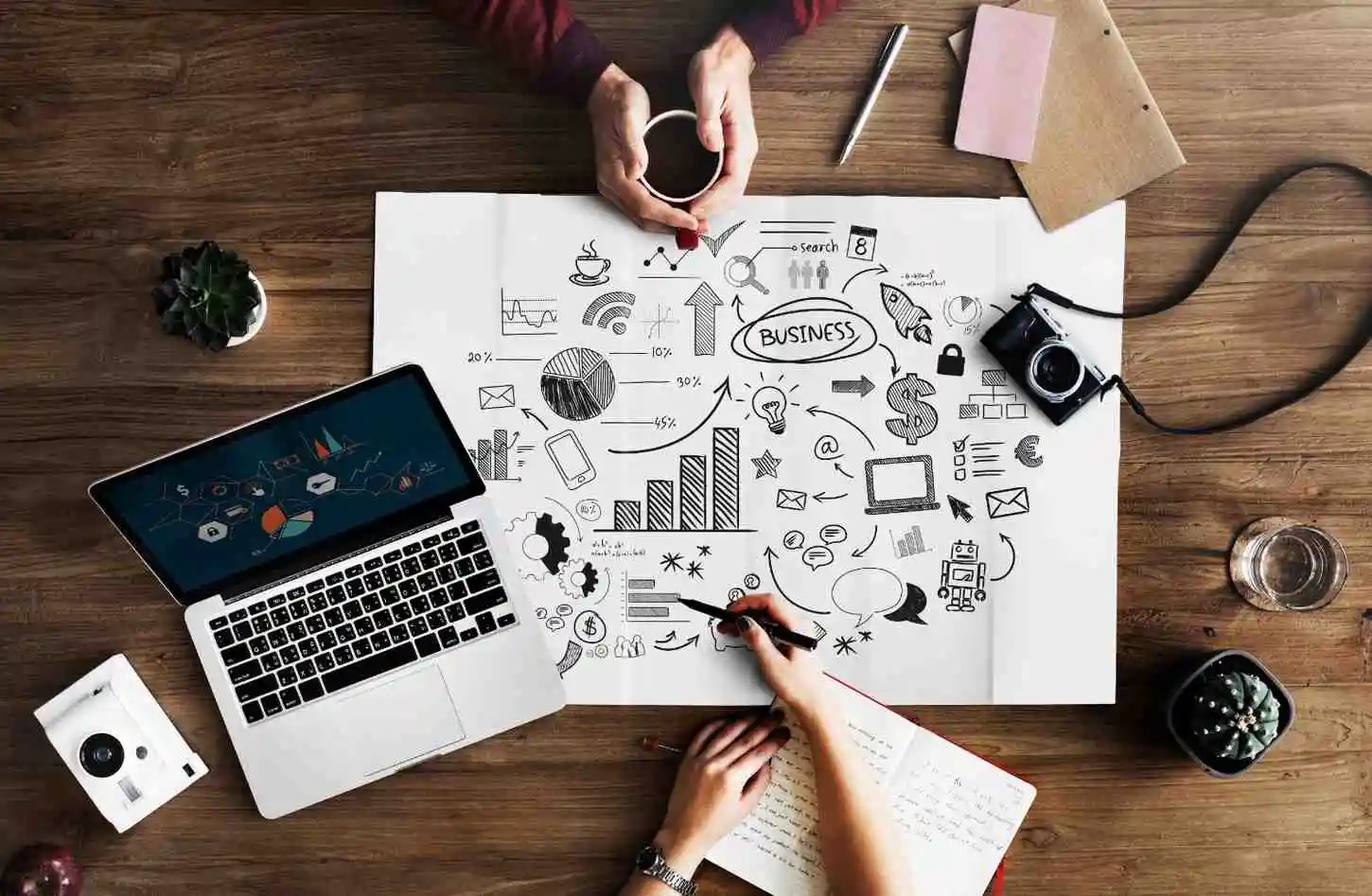 People planning digital marketing ideas with a laptop and workspace
